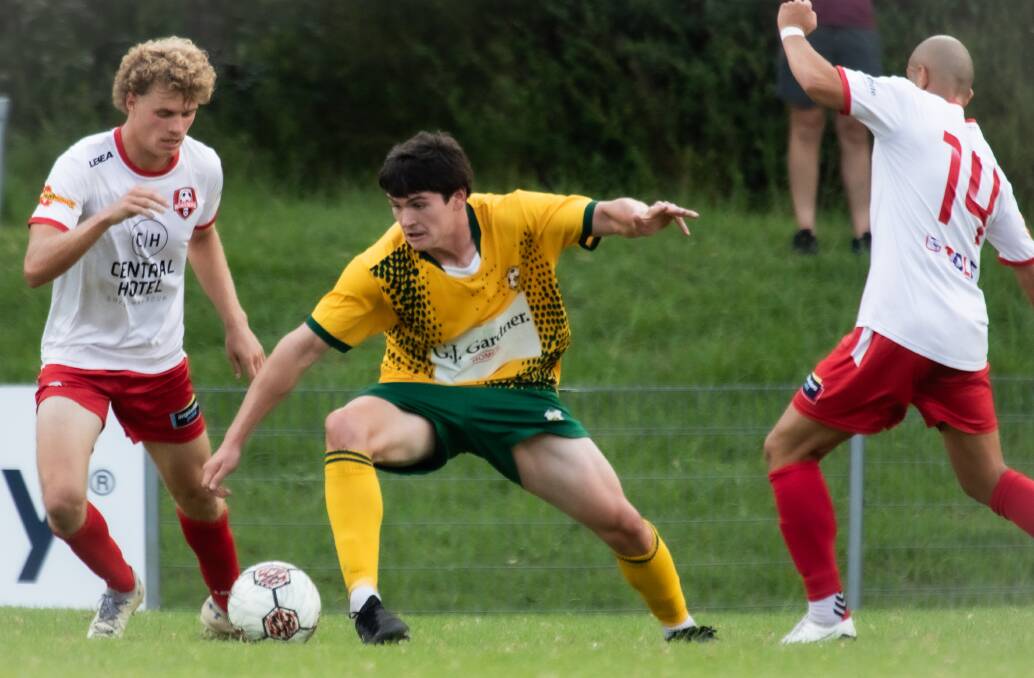 Jaxon Scholtz keeps control of the ball, despite close attention from Warilla Wanderers opponents. Picture by Team Shot Studios.