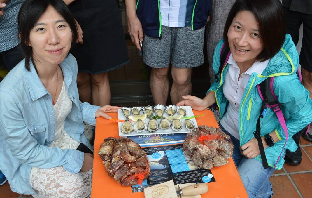 EXPORT POTENTIAL: Luo Kang and Ruiyan Ding sample the best on offer from Australia's Oyster Coast.