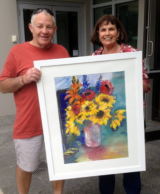 COLOURS: Wilma Southan (right) presenting her painting to Dennis Ogilvie (left). Image: supplied. 
