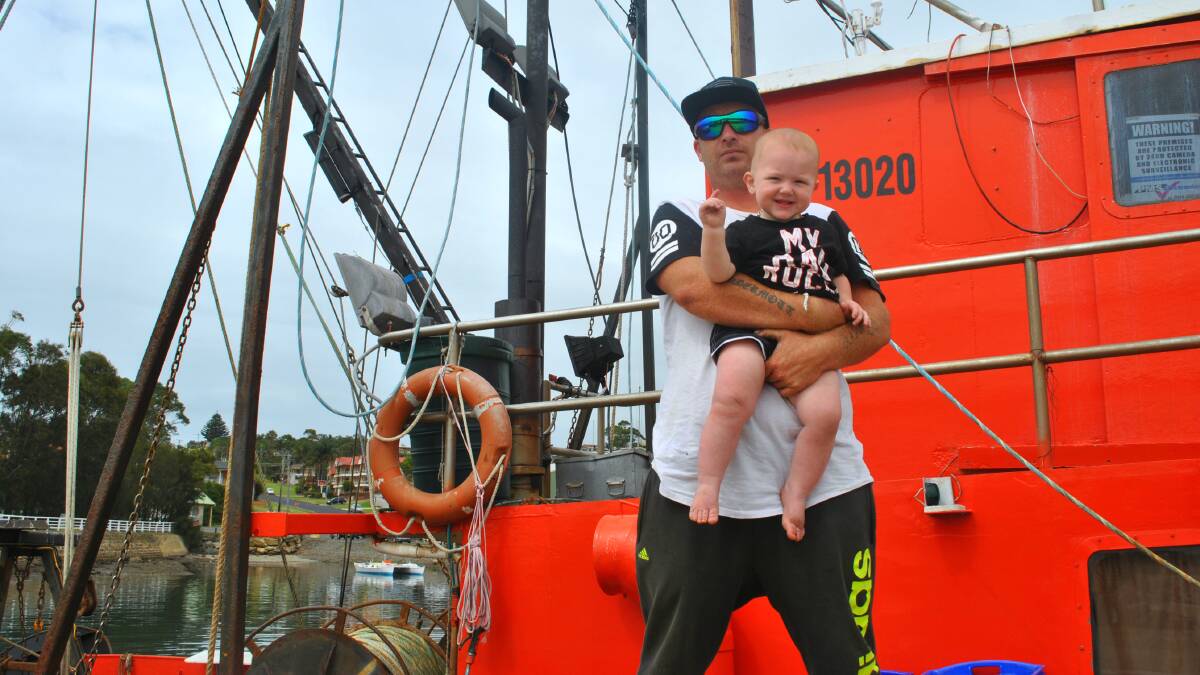 FOUR GENERATIONS: Daniel McDermott and his son Rocco in front of their boat the Shelley H. The McDermott’s have fished the waters off Ulladulla for 30 years and are worried pair-trawling will damage the local industry. 