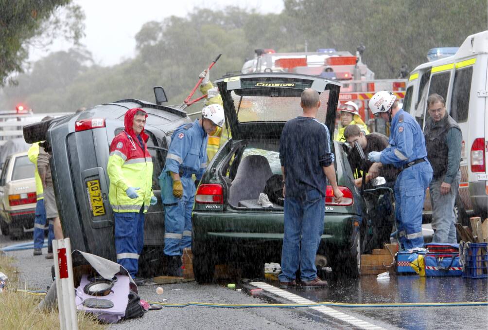 Emergency services work in the rain on Picton Road, in the aftermath of the fatal crash. 