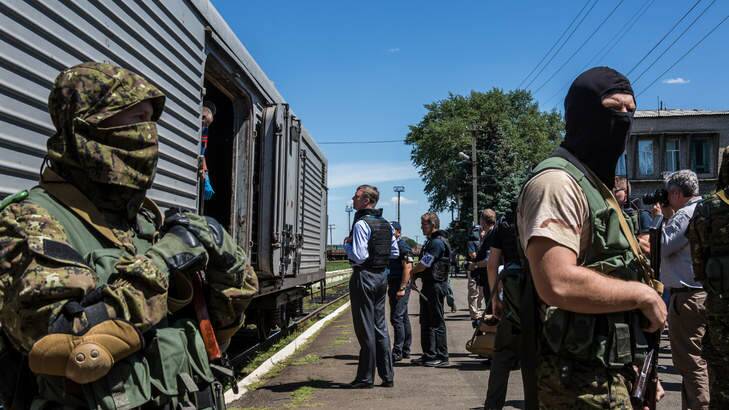 Alexander Hug (centre), Deputy Chief Monitor of the Organisation for Security and Cooperation in Europe (OSCE) Special Monitoring Mission to Ukraine, visits a train containing the bodies of victims of the MH17 crash in Torez, Ukraine as pro-Russia rebels guard the site. Photo: Getty Images / Brendan Hoffman