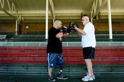 No giving up: Brad Hardman with boxing trainer Johnny Lewis. Photo: Steven Siewert