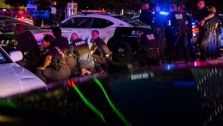 Dallas police officers take cover during the attack. Photo: Ashley Landis/The Dallas Morning News via AP