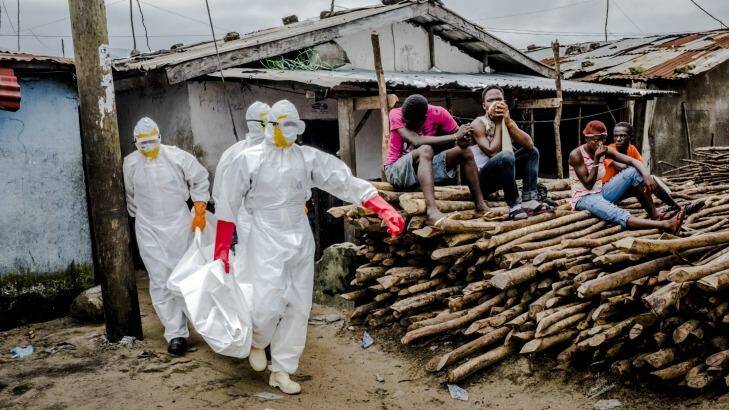 A burial team removes the body an Ebola victim from an isolation ward in West Point, Monrovia. Photo: New York Times
