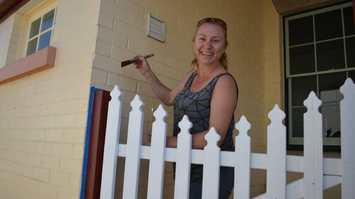 FINAL TOUCHES: Ainsley Rouse putting a final coat of paint on the verandah.