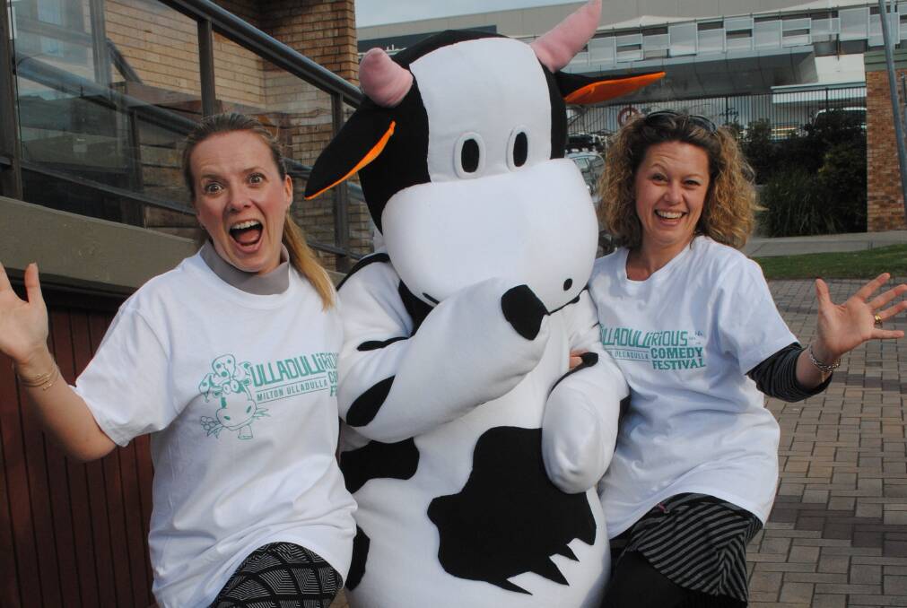 ON THE MOOVE: Ulladullirians Sarah Watterson and Kylie Rushton with Milton The Cow dancing in the streets to promote the up-coming comedy festival.