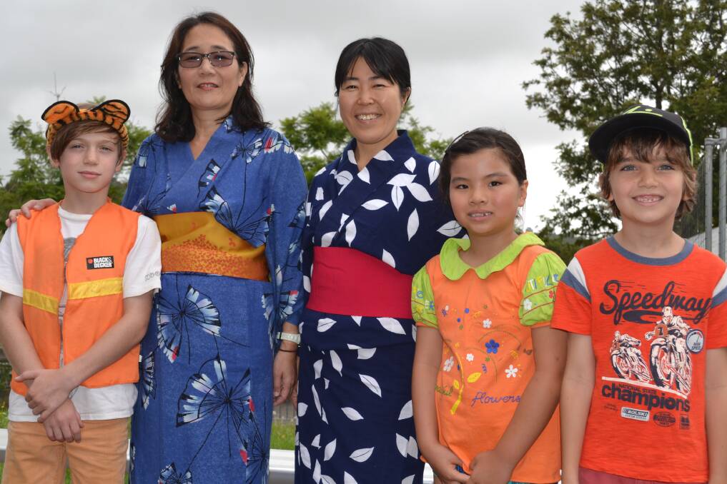 WE ARE ONE: Milton Public School students Noah Abbott (left), Chelsea Soo and Sam Goodworth pictured with Takako Holstegge and Ryoko Hayashi following their Japanese performance at the Harmony Day assembly on Friday.