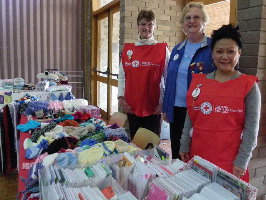 PLENTY ON OFFER: Milton Ulladulla and District Red Cross members Margaret Peppitt, Gill Rolfe and Rose Wright show off their items for sale on their stall at Wesley Hall in Nowra.  