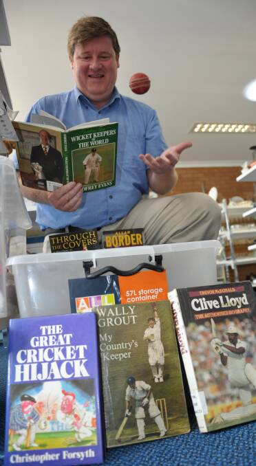 I DON’T LIKE CRICKET, I LOVE IT: St Vinnies Shoalhaven regional manager Rod Douglass checks out one of the 500 cricket books that were dropped off at Vinnies Ulladulla last week. 