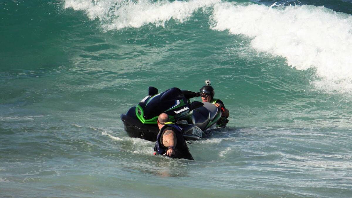 IN TROUBLE: A man on a jet ski is swamped at the Bommie on Saturday, but is washed up onto the sand. Photo by Bill Hill.