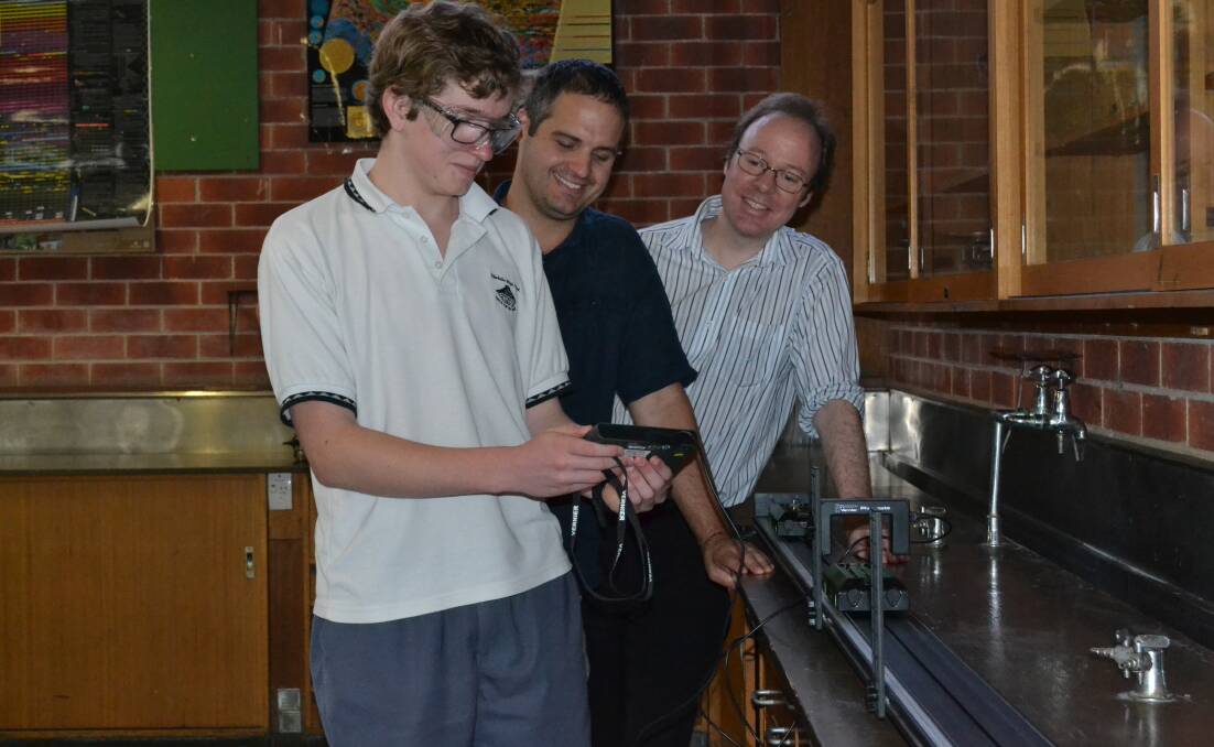 PASSIONATE ABOUT PHYSICS: David Robertson, his teacher, Josh Westerway and Scientrific representative, Stuart Lewis collect data from the dynamics track in the school science lab.