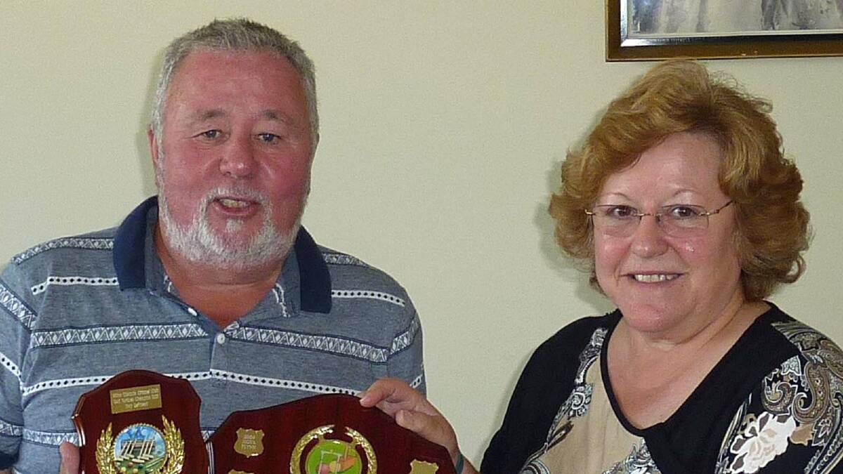 The Golf Novices Champ Tony De Friend is presented with his trophy by club president, Dee Carrington. 