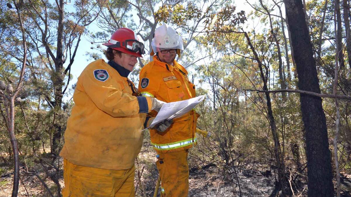 FINISHING OFF: Jacquie Cox and Bryan Green from Callala Beach RFS brigade start the process of blacking out hotspots on the Wandandian fire ground.