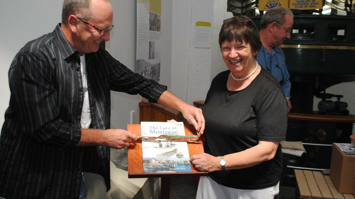 NAROOMA: Former National Parks Discovery Ranger   Mark Westwood undoes the ribbon, launching the   third edition of “The Lure of Montague” with   author Laurelle Pacey at the Narooma Visitors   Centre.
