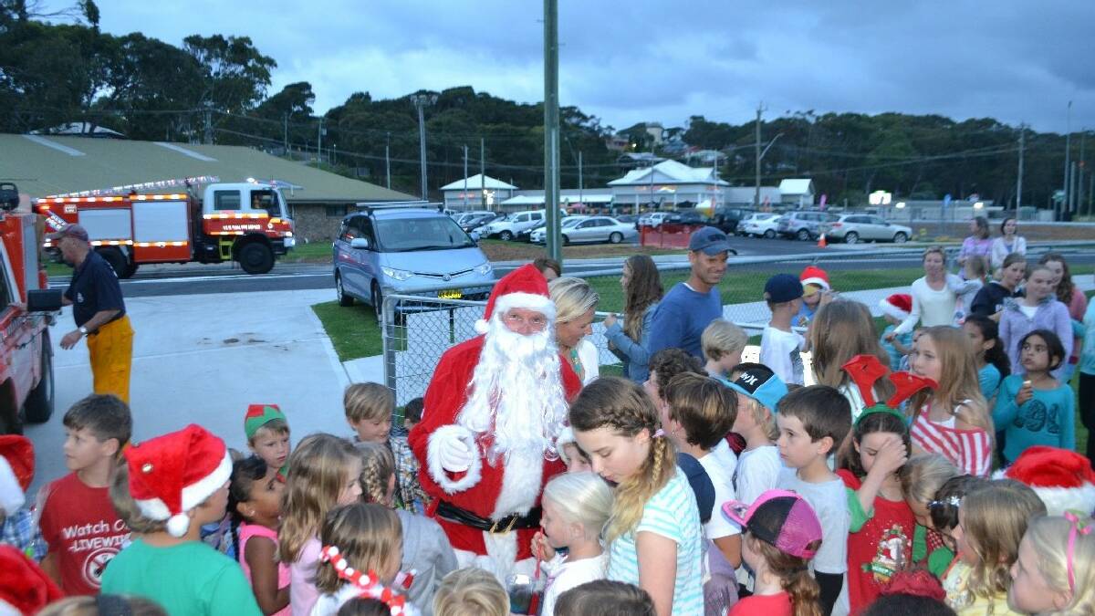 NAROOMA: Great excitement when Santa arrived at   the Narooma Christmas carols at NATA Oval on   Sunday on the back of a RFS fire engine.
