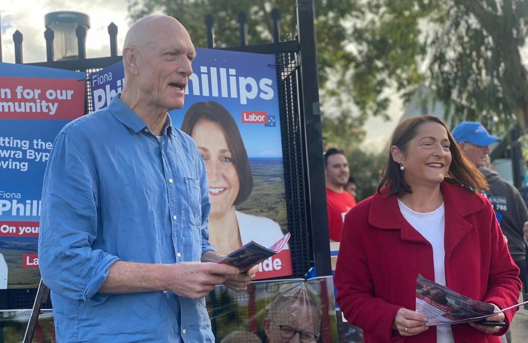 Peter Garrett handing how-to-vote cards alongside Labor's Fiona Phillips at Bomaderry Public School on Election Day 2022. Picture: Grace Crivellaro.