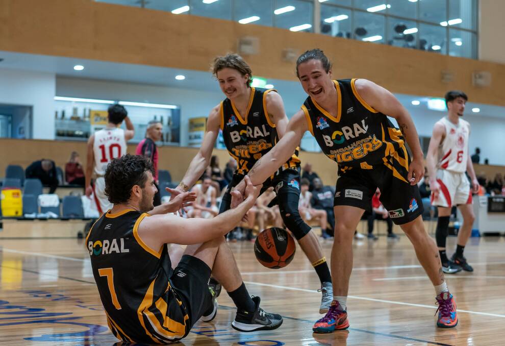 ALL SMILES: Tigers' Rory Shepherdson (Left) and Corey Walker (Right) helping up Lachlan Armstrong in their dominant victory against St George. Picture: SHOALHAVEN BASKETBALL ASSOCIATION