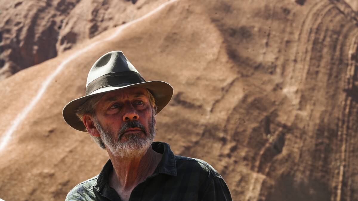 Goanna singer-songwriter Shane Howard in front of Uluru. (AAP Image/Lukas Coch)