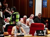 Security guards order people to remove T-shirts or be evicted from the public gallery at the March 25 Shoalhaven Council meeting. Picture by Richard Miller.
