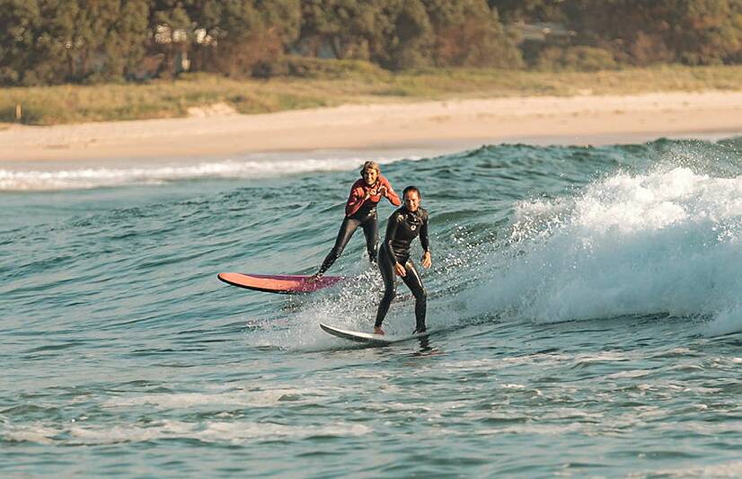 Petty Officer Hannah Stiles and Pam Burridge ride a wave during the Australian Defence Force women's surf development camp in Ulladulla. Picture by ABIS Jasmine Moody