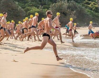 SPEED: Competitors enter the water during last year's annual ocean swim.