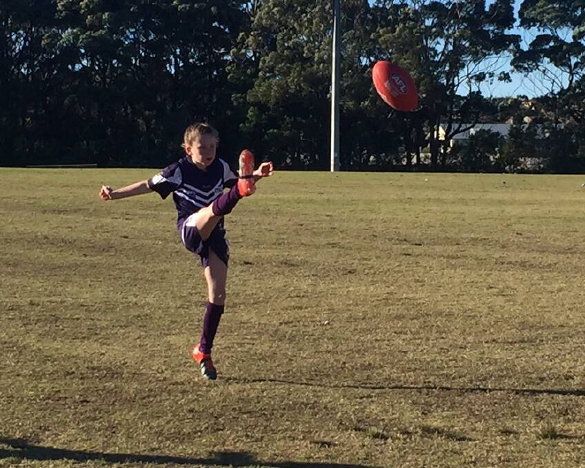 BIG BOOT: Lyla kicking a goal for the Ulladulla Dockers in a recent match.