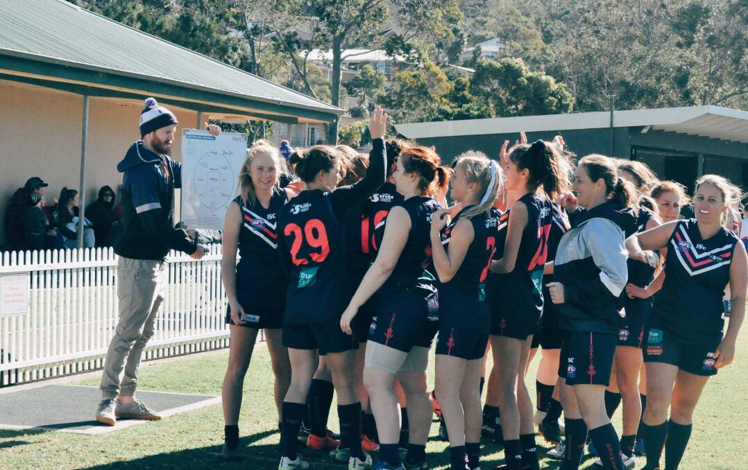 Close-knit team: The Dockettes and head coach Daniel talk tactics. The girls have a top-of-the-table clash against Dapto this weekend. 
