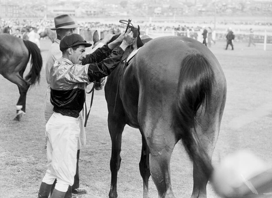 Darby Munro, unsaddles racehorse, Shannon, after winning the King's Cup at Randwick in Sydney on October 12, 1946.