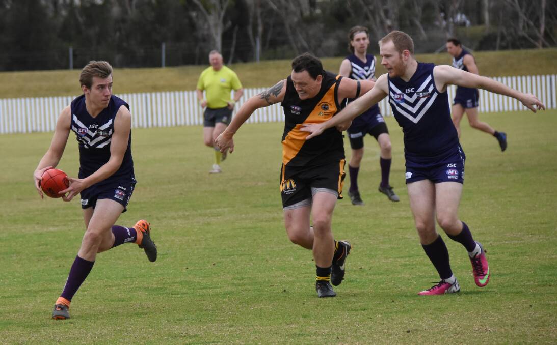 EYES UP: Dockers' Michael Moran looks for a passing option, while team mate Luke Evans shepherds Tigers' Christian Mills. Photo: COURTNEY WARD