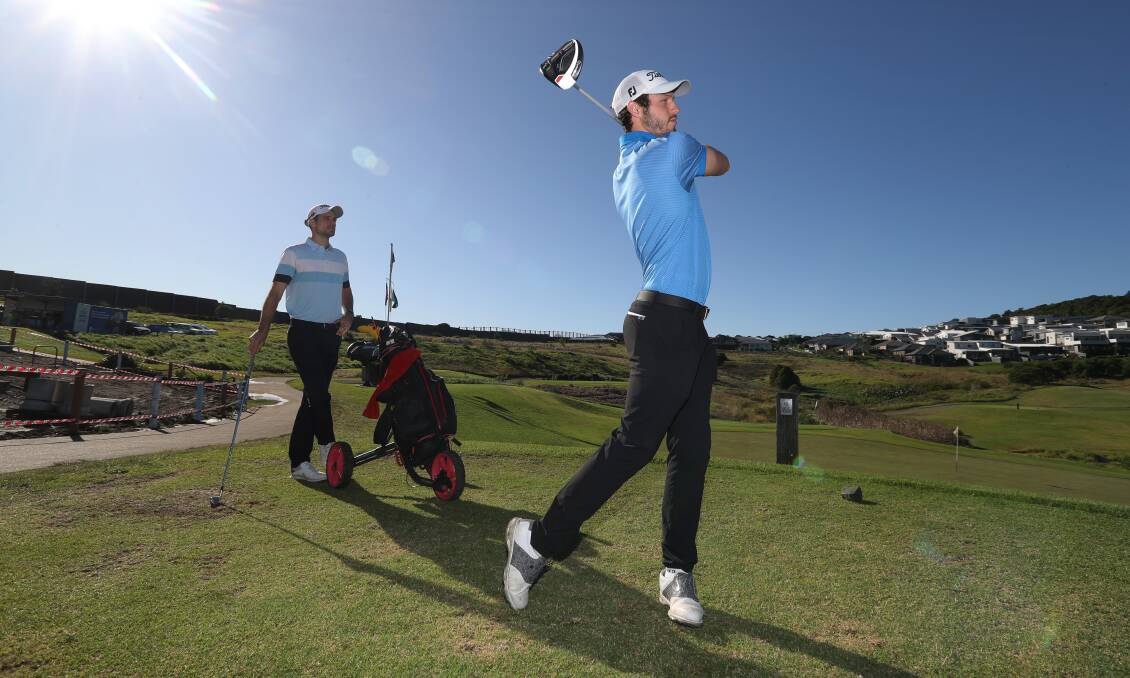 Kyle Zunic tees off as older brother Jordan watches on at Shell Cove Links. Photo: Robert Peet
