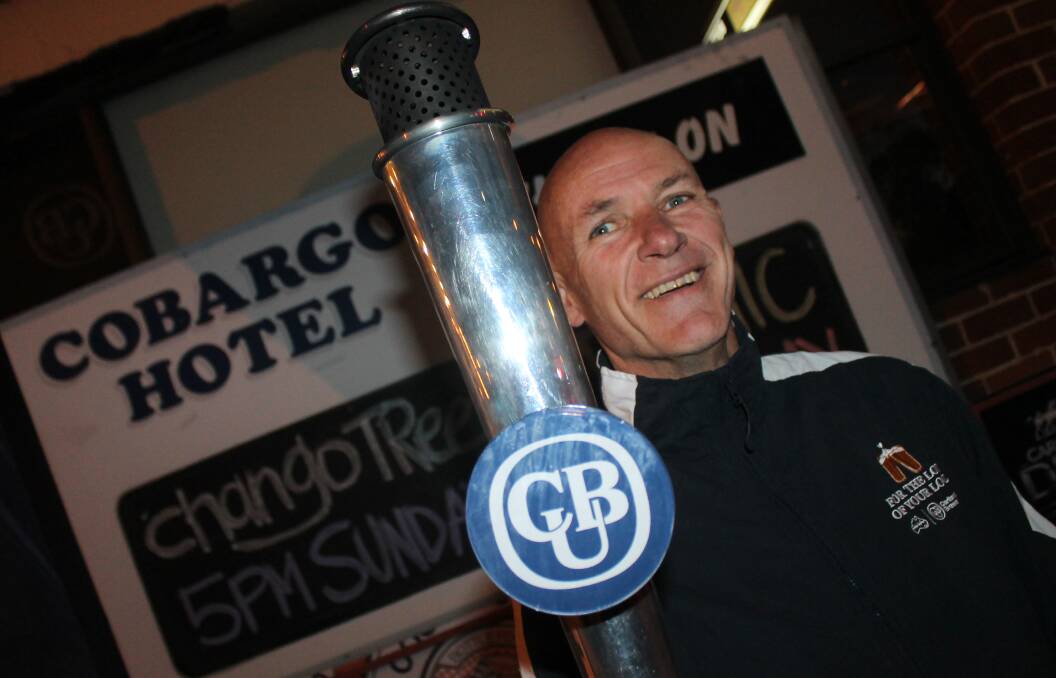OPEN FOR BUSINESS: Cobargo's Rod Vickers holds the torch that is being carried around the country for the Carlton & United Breweries' 'pub crawl'. 