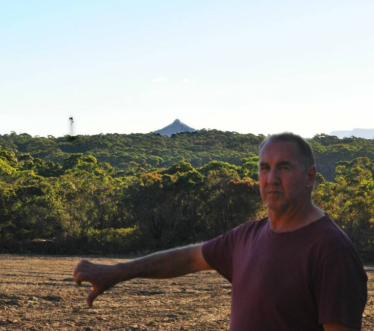 EYE SORE: A new Optus phone tower erected south of Burrill Lake near the Princes Highway has ruined Dolphin Point resident Don Stedman's view of an icon of the area - Pigeon House Mountain. Photo: Sam Strong.