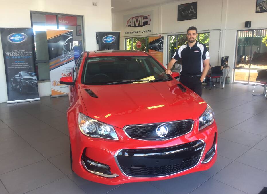 AMH Auto Group Sales Manager Richie Bardon with a red SS V-Series Redline Commodore. 