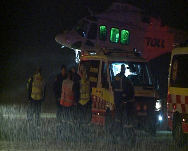 LIFT OFF: The Toll NSW Ambulance Rescue Helicopter takes off in pouring rain from the crash scene at Wandandian.