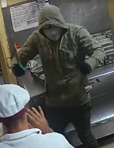 The terrifying moment one of the armed offenders confronts a bakery staff member.