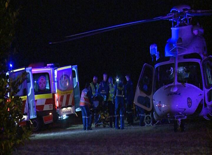 AID: NSW Ambulance personnel take one of the injured to one of two Toll NSW Ambulance Rescue Helicopters at the Wandandian crash.