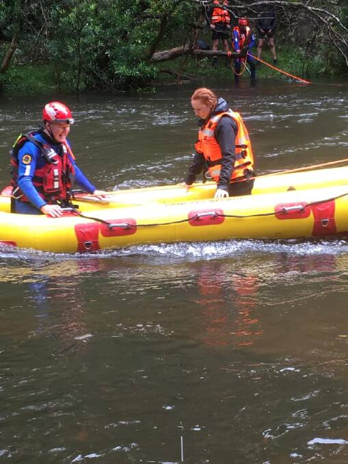 RESCUE: One of the stranded Sydney scouts is taken to safety onboard the Ulladulla SES Unit's Angel Arc inflatable rescue craft by flood rescue team members Bill Frazer and Gary Smith. Image: Ulladulla SES
