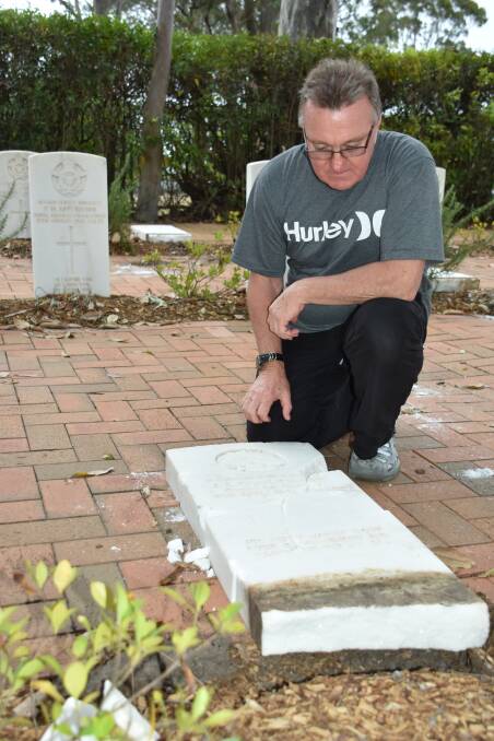 SHATTERED: Well-known local veteran and chairman of the Keith Payne VC Veterans Benefit Group, Rick Meehan inspects the damage to one of five graves damaged in the Nowra War Cemetery.
