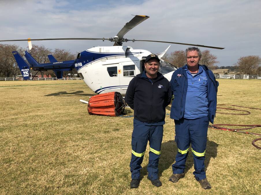 Helicopter pilot Allan Tull (right) just moments before he took off from Milton Showground on what would be his last flight. He is pictured with fellow pilot Kevin Drake, who was also fighting the Kingiman fire from the air. Photo: John Hanscombe