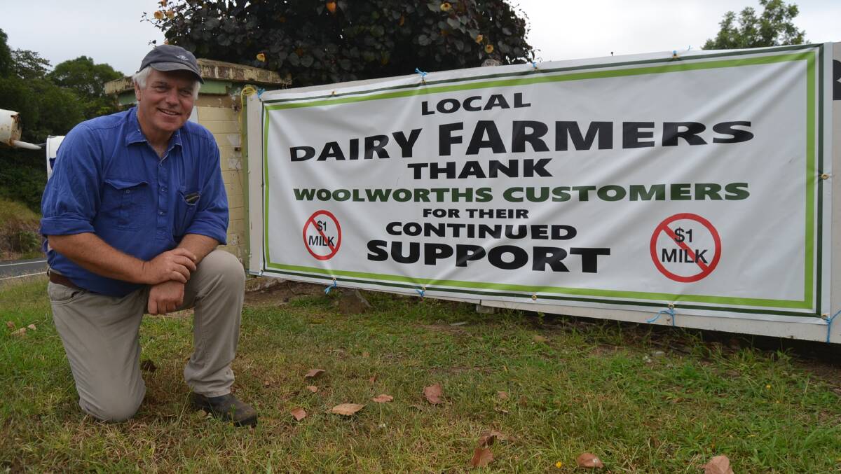 CAMPAIGN: Dairy farmer Robert Miller unveils his new sign, praising Woolworths for ditching its $1 a litre milk.