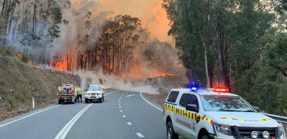 The fire crosses the Kings Highway at Government Bend on Thursday morning. Picture: Fire and Rescue NSW Station 477 Ulladulla. 