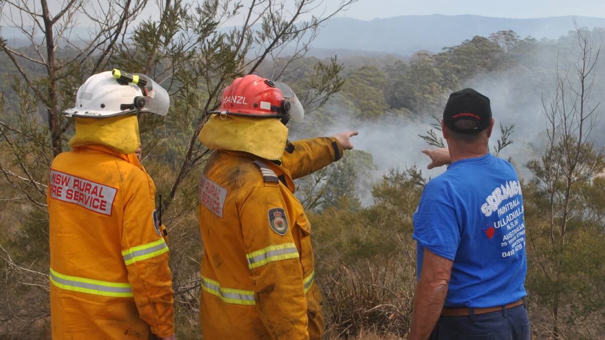 LOCAL KNOWLEDGE: Carwoola Rural Fire Service firefighters talk with Rick Walker about the best way access to a spot fire west of Woodstock Road.