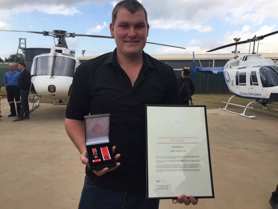 Joseph Tull accepts his father's posthumous award at the Sydney Helicopters' base in Granville. Picture: Emily Barton.