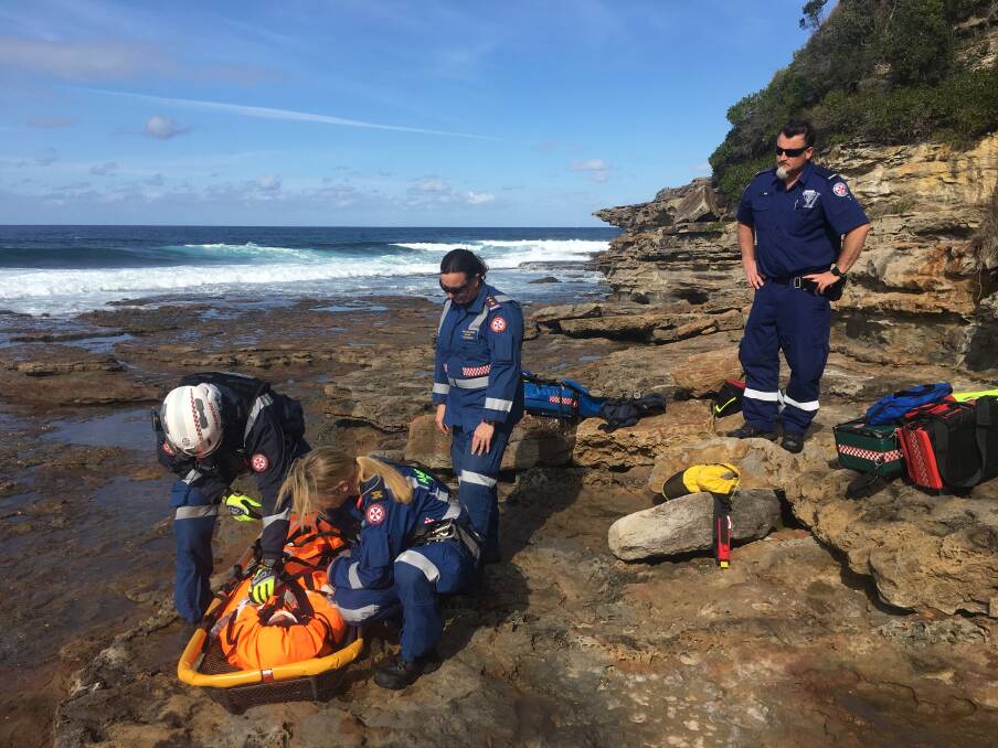 INCIDENT: NSW Ambulance paramedics stabilise the bodyboarder on the rocks. Pictures: supplied.