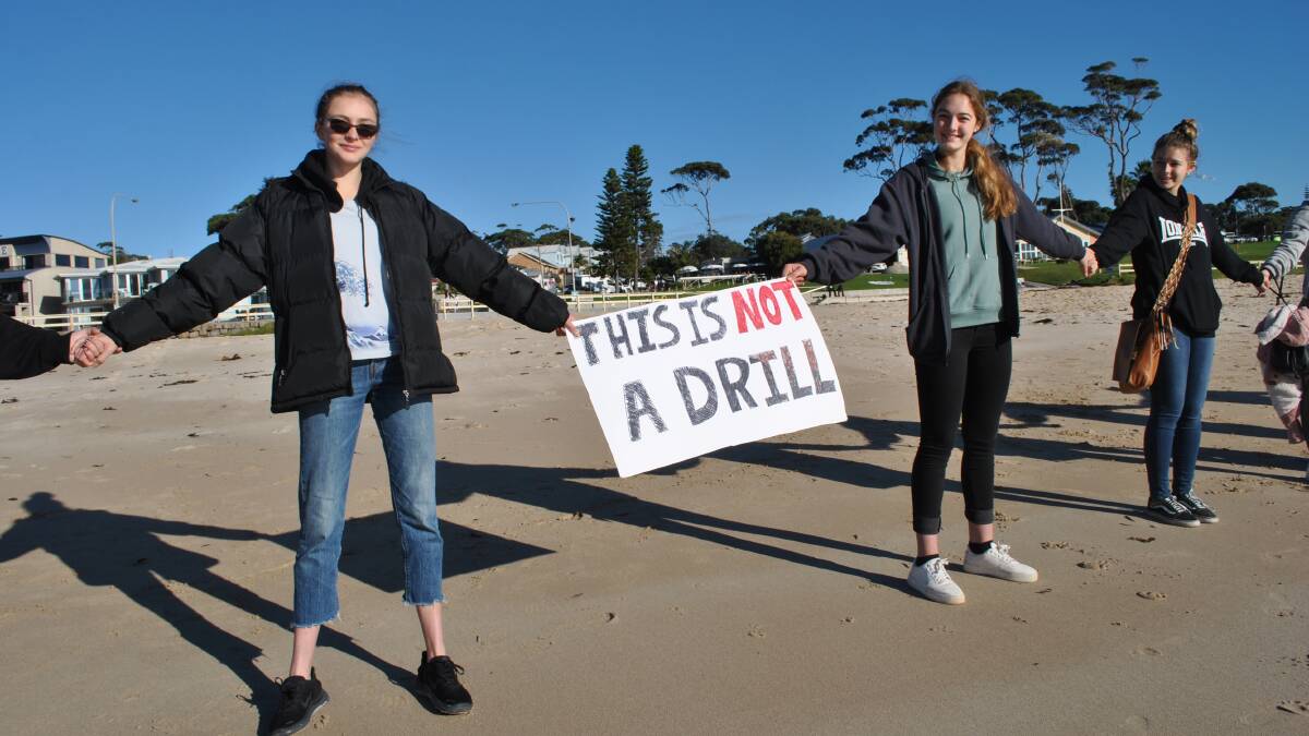 PROTEST: Teenagers Isabella Vinson and Neve Lawson join Hands Across the Sand campaign at South Mollymook.