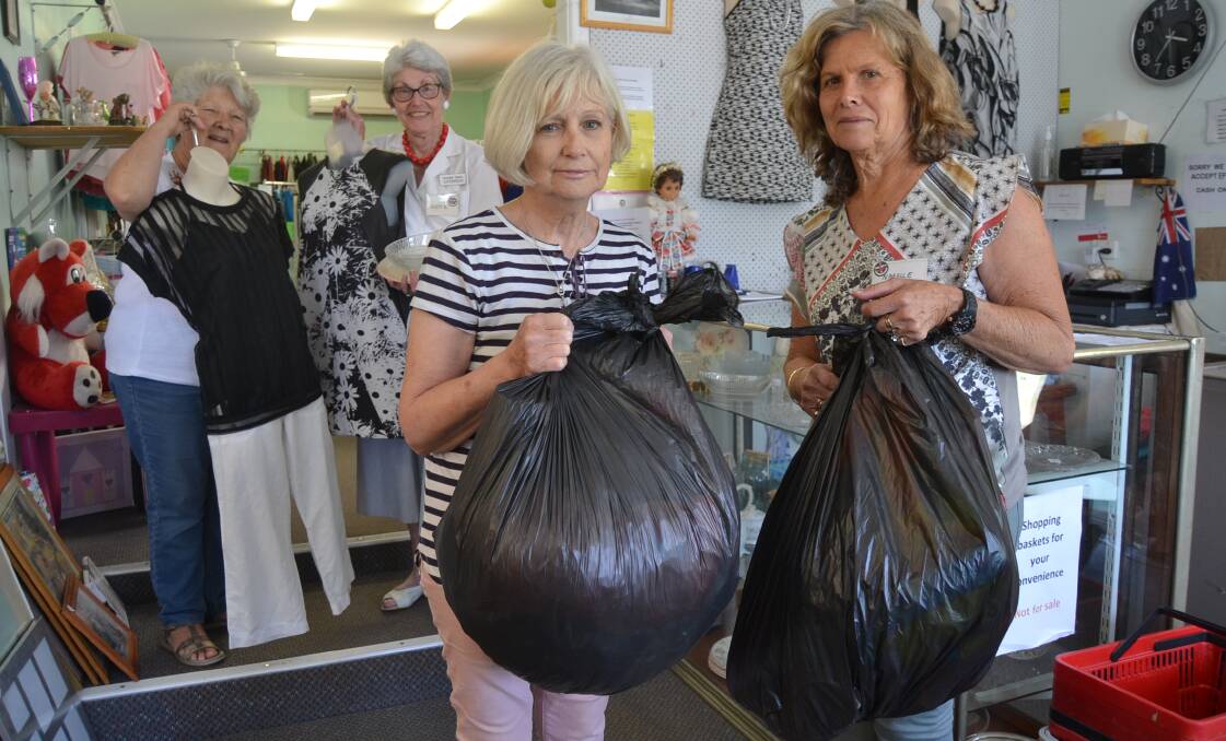 Outreach Centre volunteers Christine Moss and Judy Byrant hold dresses that meet their policy of 'goods we will buy' while Sonia Workman and Narelle Magnusson dispose some of non-useable goods the centre has received.