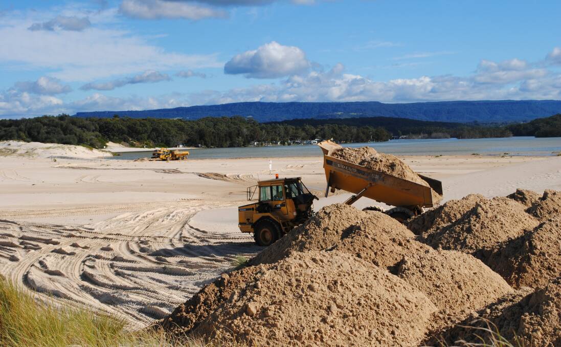 Contractors dump sand after removing it from the entrance of Lake Conjola on June 13.