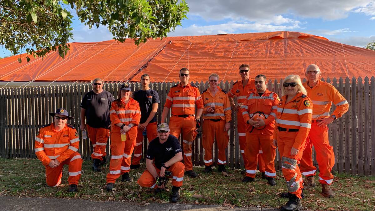 ROOF TARPED: Members from team Bravo, Tracy Provest's Strike Team (Tracy was responsible for three teams), John McCloghry team leader, and another team leader from Shellharbour, Ray Metz (kneeling at front). Photo supplied. Tracy