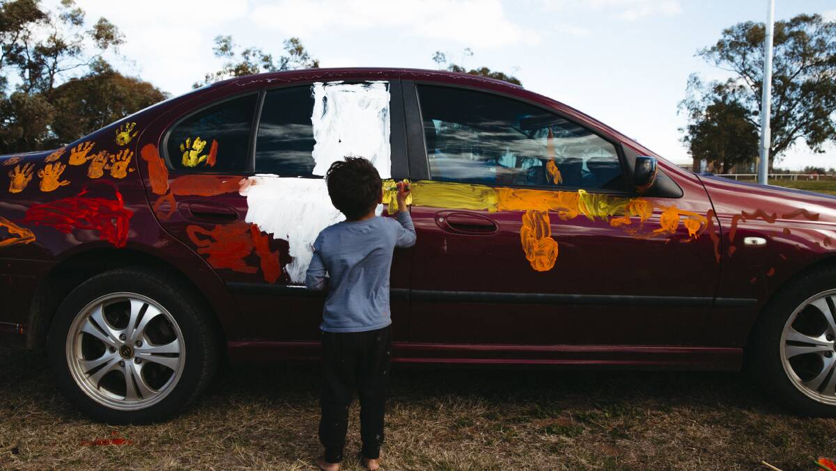 Local kids painting cars at the Football Paint-Up at Wilcannia, NSW, to support their local football team the Wilcannia Boomerangs in the grand finals. Picture: Dion Georgopoulos